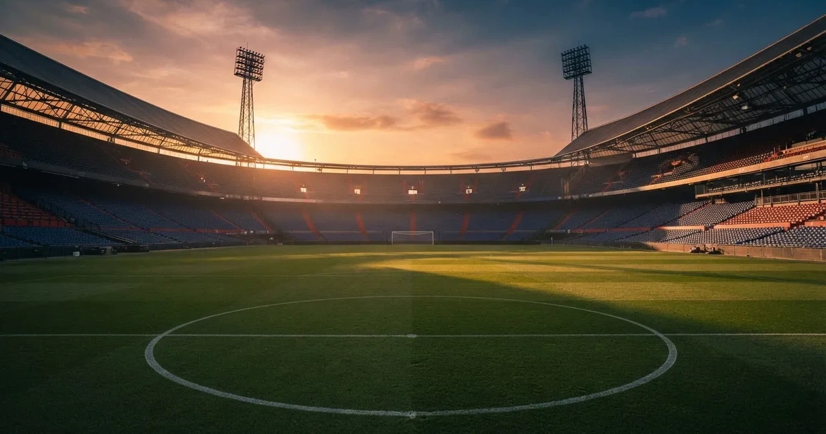Un estadio de fútbol vacío con torres de iluminación al atardecer